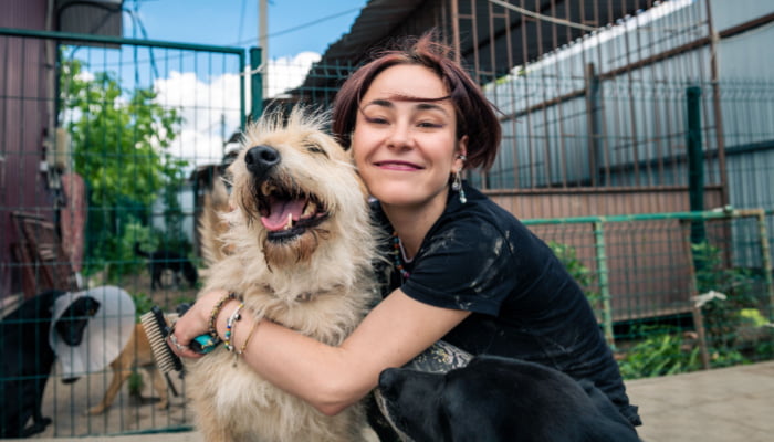 Woman hugging a happy dog at the shelter